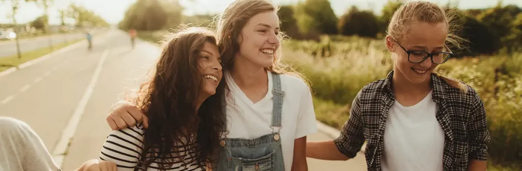 Tre ragazze in Exchange che camminano per strada e si abbracciano